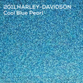 A close-up textured paint swatch of a blue glittery material with white text reading '2011 HARLEY-DAVIDSON Cool Blue Pearl' in the upper left.