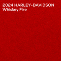 A textured red color paint swatch with white text in the top-left corner reading '2024 HARLEY-DAVIDSON Whiskey Fire'.